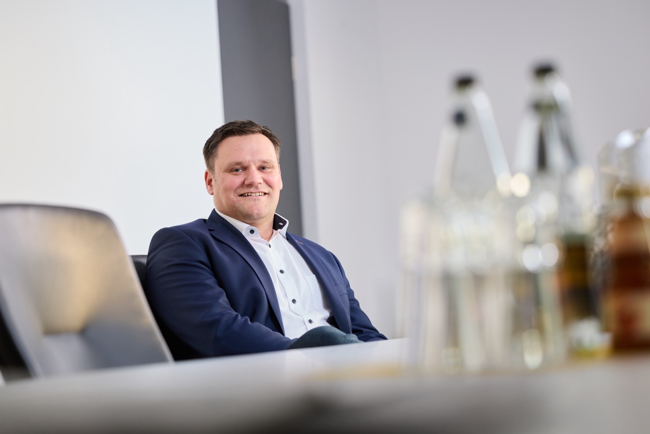Geschäftsführer Jörn Ermel sitzend an einem Besprechungstisch