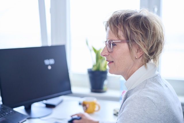 Bild einer Mitarbeiterin vor einem Bildschirm