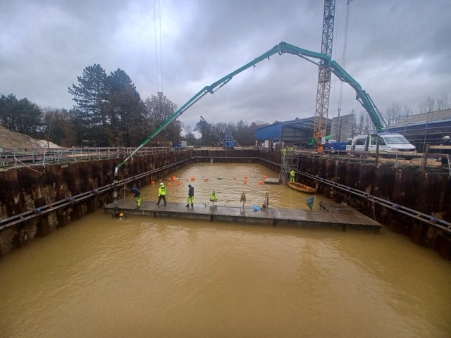 Bild eines Betonkranes welcher Beton in eine Baustelle pumpt
