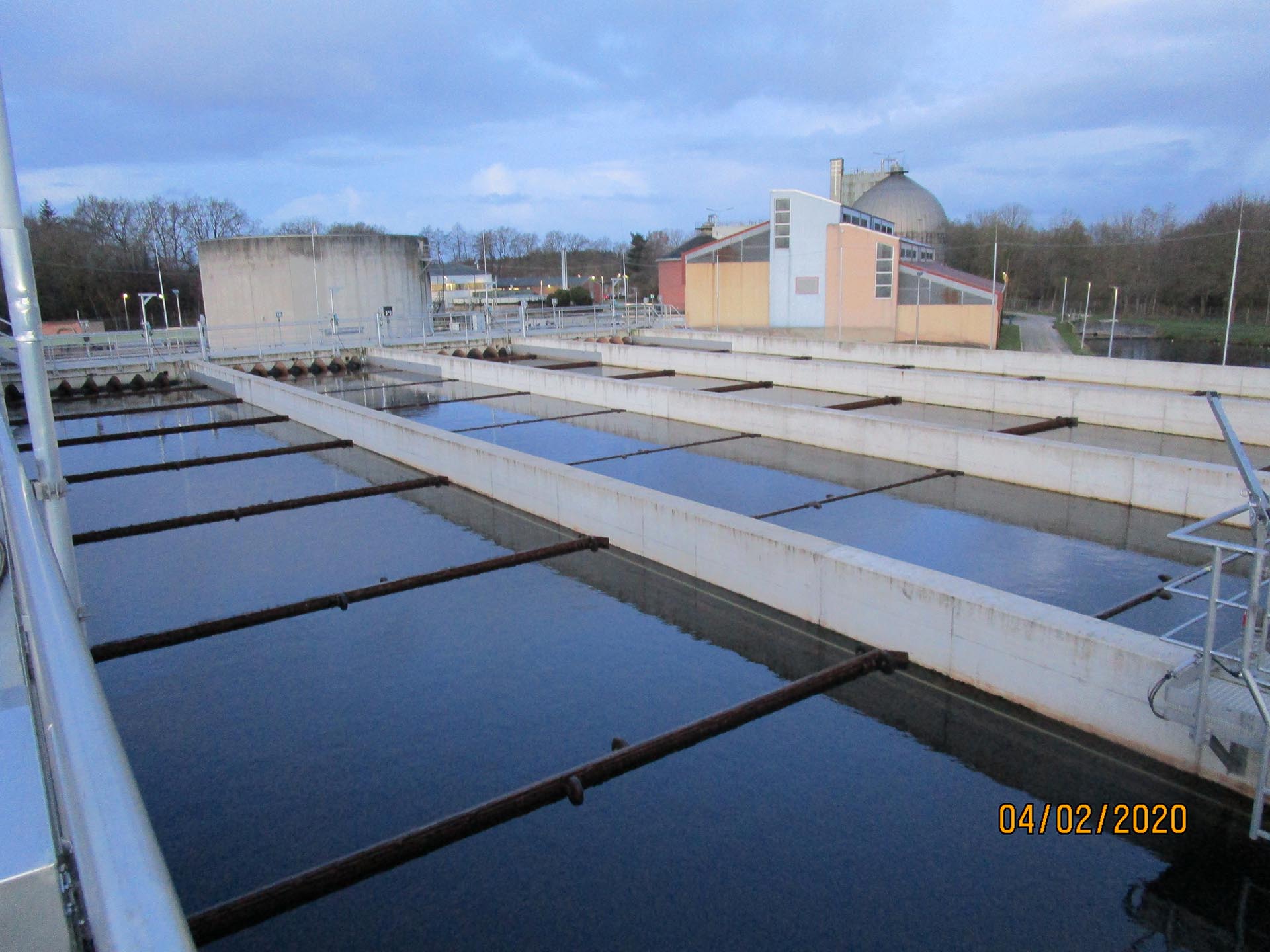 Längsdurchströmte Nachklärbecken mit Wasseroberfläche und Räumtechnik auf einer Kläranlage