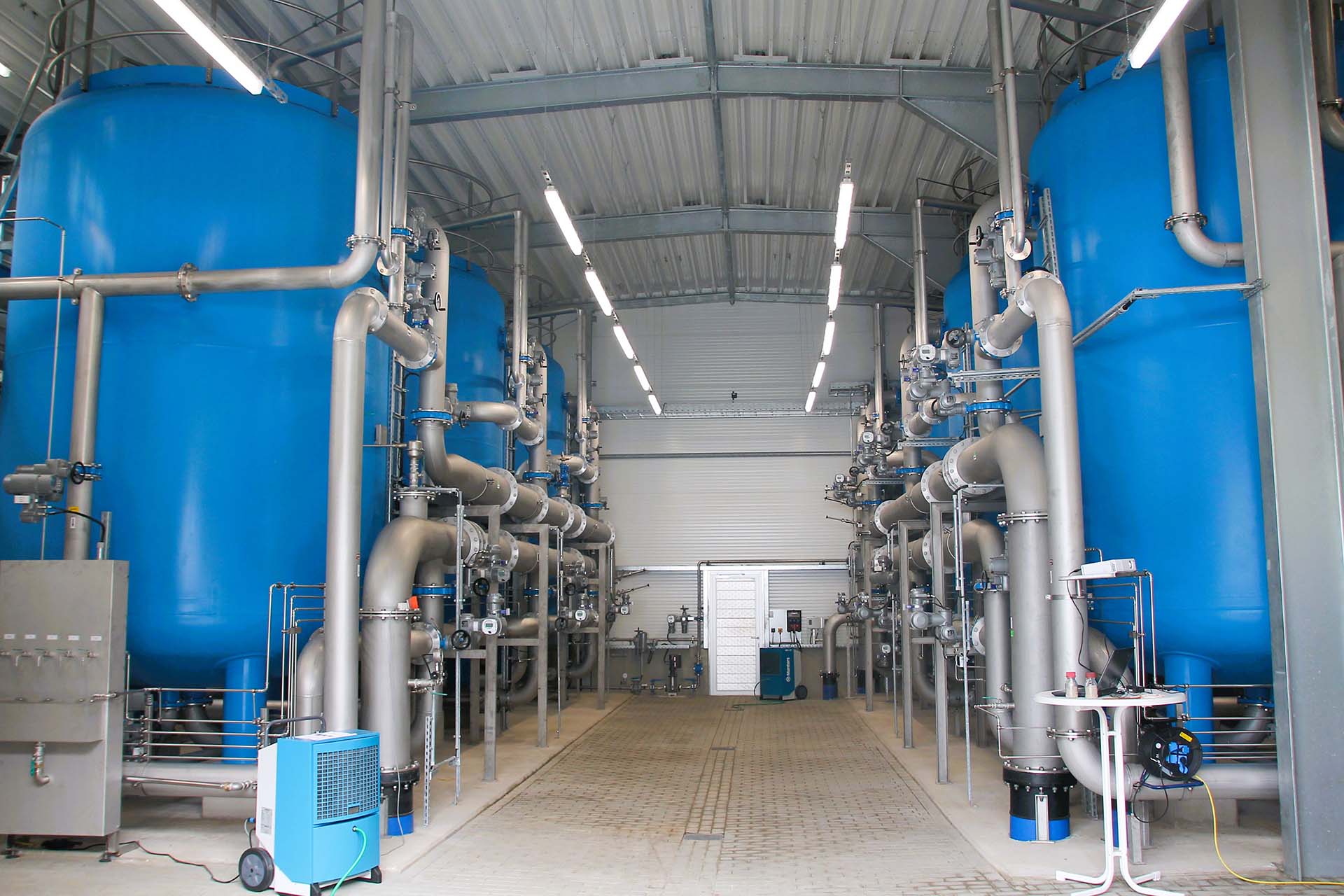 Innenansicht einer Wasseraufbereitungsanlage mit großen Filterbehältern und Rohrleitungssystem