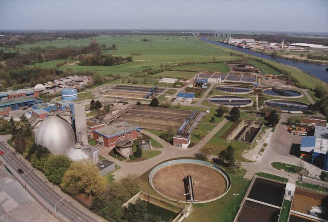 Luftaufnahme der Kläranlage Oldenburg mit Becken, Faulturm, Betriebsgebäuden und angrenzendem Kanal