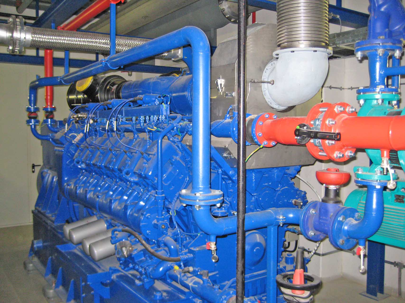 Erdgas-Blockheizkraftwerk mit Gasmotor, Rohrleitungen und Wärmenutzungstechnik in einer Produktionsanlage