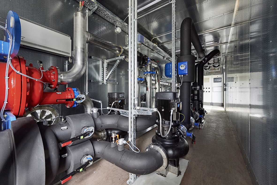 Kältezentrale in Containerbauweise mit Pumpen, Rohrleitungen und Steuerungstechnik zur zentralen Kälteversorgung